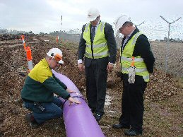Qenos employees inspect the pipe laying process.